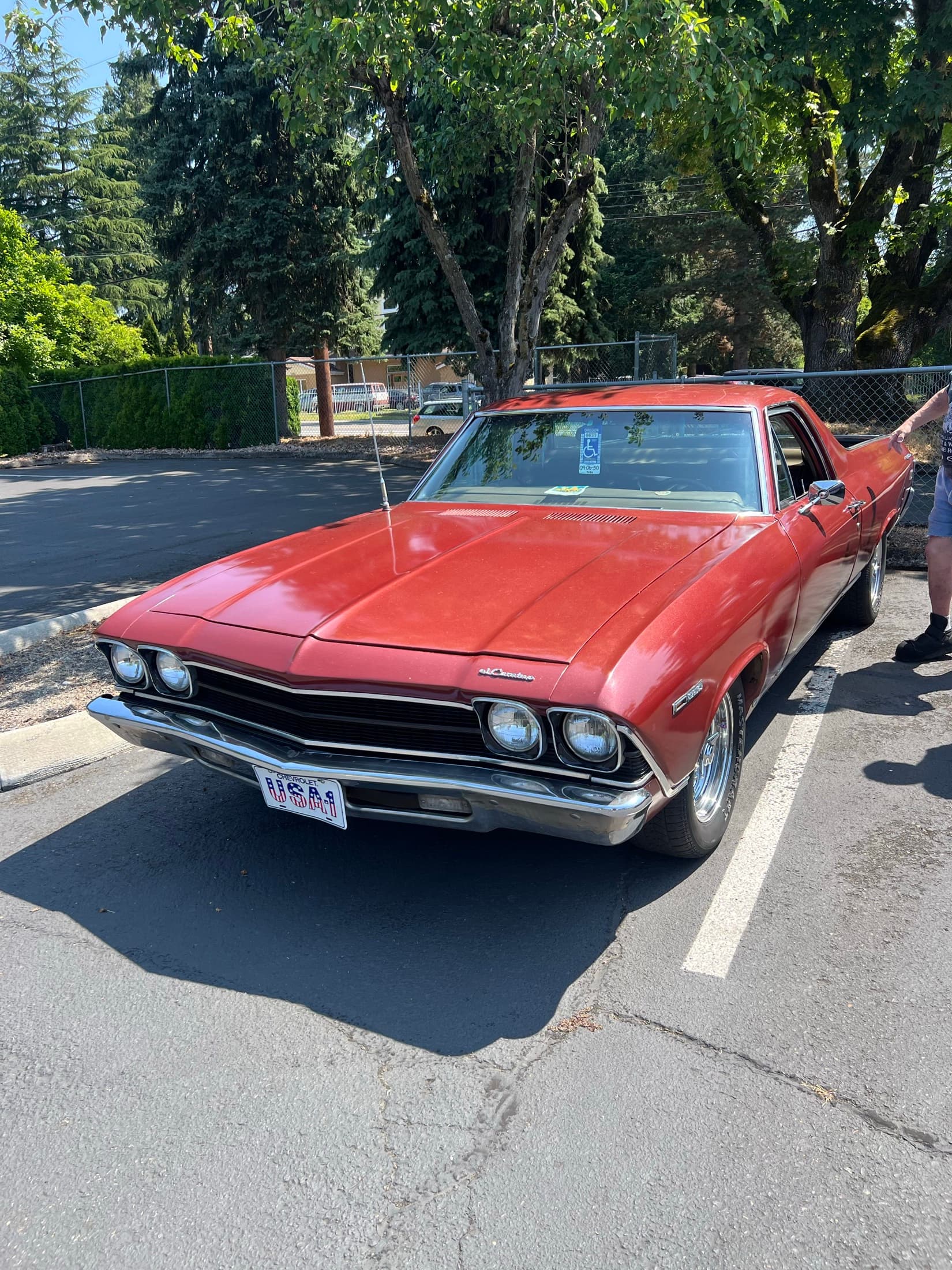 Orange coupe with hood open at the event.
